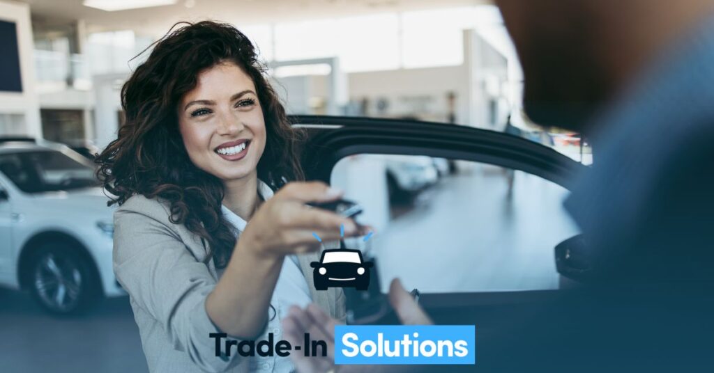 A woman holding up her car keys in the back of a vehicle.